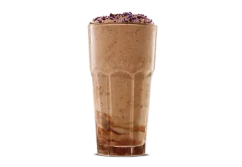 Morticia's Kooky Chocolate Shake topped with whipped cream and chocolate drizzle in a glass cup